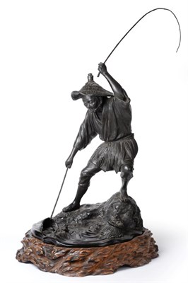 Lot 140 - A Japanese Bronze Figure of a Fisherman, Meiji period (1868-1912), standing on a rock landing a...