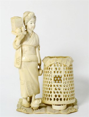 Lot 143 - A Japanese Ivory Okimono, Meiji period (1868-1912), as a girl standing holding boxes, a chicken...