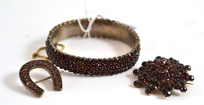 Lot 41 - A small quantity of jewellery, including a bangle and two brooches set with red stones