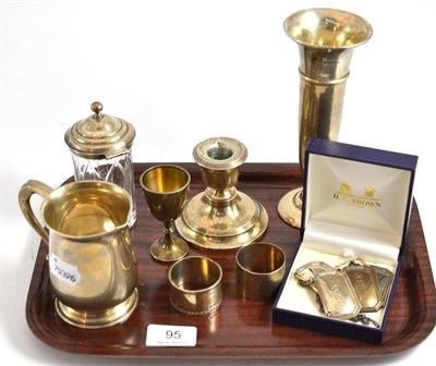 Lot 95 - A silver mug, silver spill vase, silver loaded candlestick, napkin rings and silver spirit labels