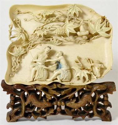 Lot 164 - A Chinese Ivory Tray, 19th century, of leaf form, carved in high relief with two figures sitting on