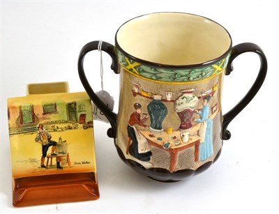 Lot 303 - Royal Doulton loving cup 'Pottery In The Past' D6696 and a Sam Weller match striker