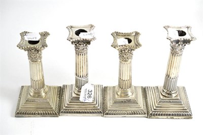 Lot 326 - A pair of silver Corinthian column candlesticks and a pair of plated candlesticks en suite (4)