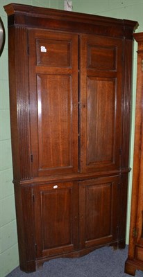 Lot 517 - A late George III oak free standing corner cupboard