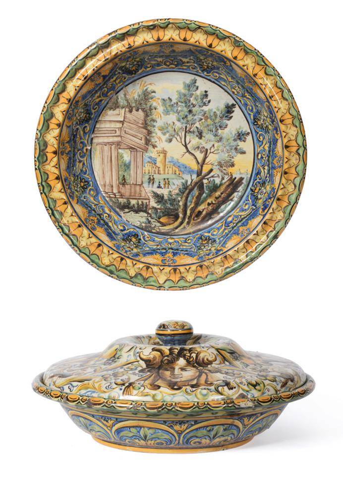 Lot 217 - A Castelli Maiolica Basin and Cover, 18th century, painted with classical ruins in landscape within