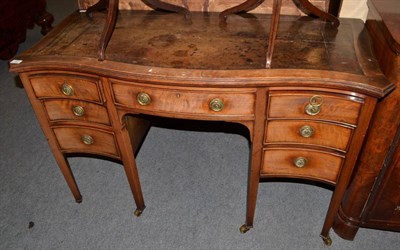 Lot 551 - An Edwardian mahogany serpentine shaped desk