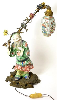 Lot 232 - A Gilt Metal Mounted Porcelain Lamp Base, in Chinese style, as a bearded figure in traditional...