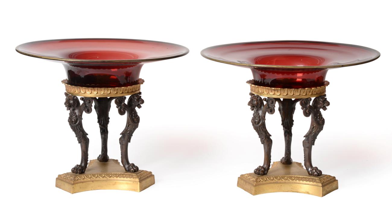 Lot 271 - A Pair of Gilt and Patinated Bronze and Ruby Glass Tazzas, in Empire style, the circular bowls...