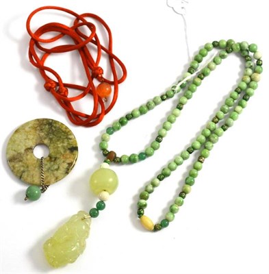 Lot 124 - A jade pendant on assorted green bead necklace and a jade disk pendant on card
