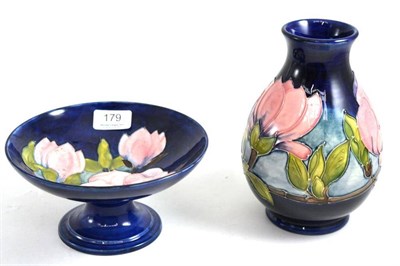 Lot 179 - A Walter Moorcroft Magnolia pattern vase, on a blue ground, impressed factory marks and green...