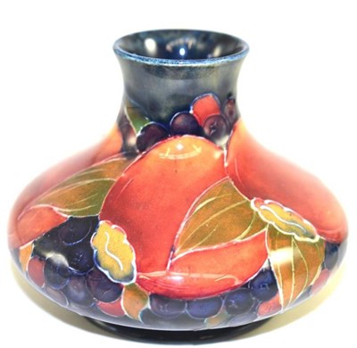 Lot 203 - A William Moorcroft Pomegranate pattern squat vase, on a blue ground, green painted signature,...