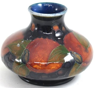 Lot 204 - A William Moorcroft Pomegranate pattern squat vase, on a blue ground, impressed factory marks...