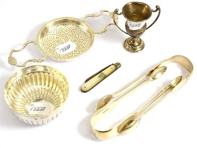 Lot 312 - # A quantity of silver comprising a sugar bowl, two pairs of sugar tongs, a strainer, a...