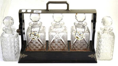 Lot 341 - The Tantalus' three bottle tantalus, inscribed 'Guilty' 1903 and two other decanters