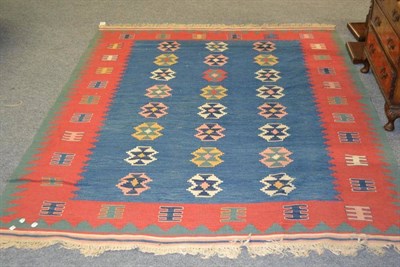 Lot 1072 - Modern Turkish Kilim, the mid blue field with three columns of stepped polychrome guls enclosed...