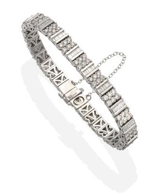 Lot 341 - An 18 Carat White Gold Diamond Bracelet, channel set baguette cut diamonds alternate with groups of