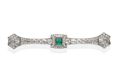 Lot 348 - An Art Deco Emerald and Diamond Bar Brooch, a step cut emerald to a tapering bar set throughout...