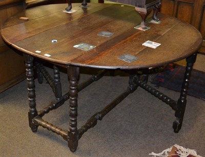 Lot 1230 - An 18th century oak gateleg table with bobbin turned supports