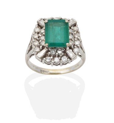 Lot 369 - An 18 Carat White Gold Emerald and Diamond Cluster Ring, an octagonal cut emerald within a two tier