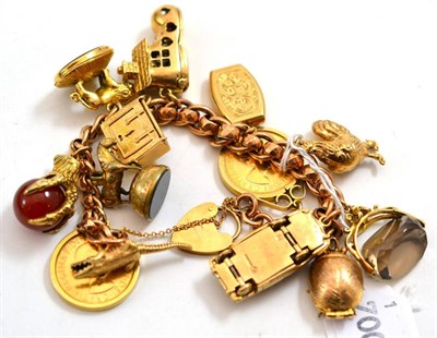 Lot 146 - A 9ct gold charm bracelet hung with twelve charms, including two 1958 sovereigns, and one loose...