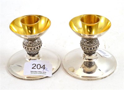 Lot 204 - A pair of silver and parcel gilt dwarf candlesticks