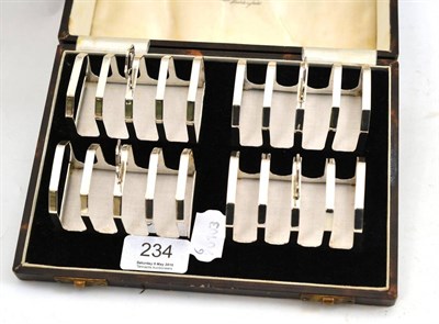 Lot 234 - A set of four silver toast racks, Birmingham 1934, in original fitted case