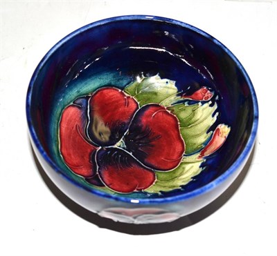 Lot 271 - A William Moorcroft Pansy pattern bowl, on a blue ground, impressed factory marks, 10.5cm diameter