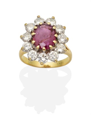 Lot 402 - A Ruby and Diamond Cluster Ring, an oval cut ruby within a border of round brilliant cut...