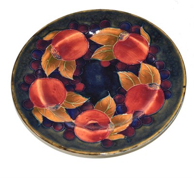 Lot 280 - A William Moorcroft Pomegranate pattern plate, on a green/blue ground, impressed factory marks...