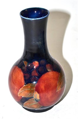 Lot 415 - A William Moorcroft Pomegranate pattern bottle vase, on a blue ground, impressed factory marks...