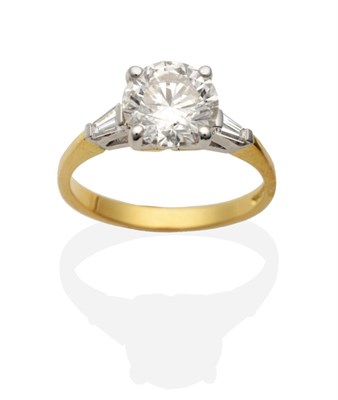 Lot 418 - An 18 Carat Gold Diamond Ring, a round brilliant cut diamond in a claw setting, to tapered baguette