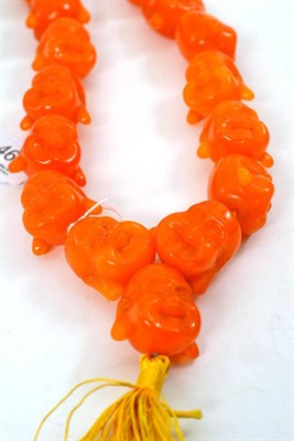 Lot 461 - Amber coloured beads, in the form of Buddha heads