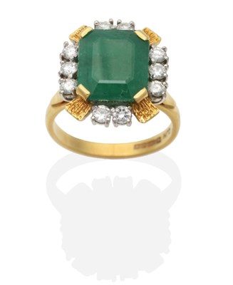 Lot 428 - An 18 Carat Gold Emerald and Diamond Cluster Ring, an octagonal cut emerald within a border of...