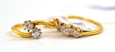 Lot 504 - A diamond three stone ring and a diamond two stone twist ring (2)