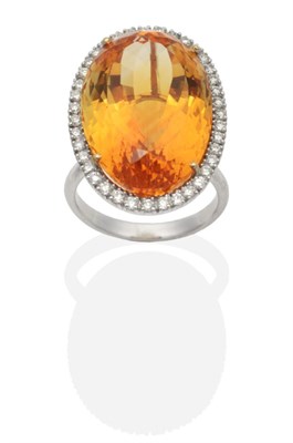 Lot 439 - A Citrine and Diamond Cluster Ring, an oval cut citrine in a claw setting within a border of...