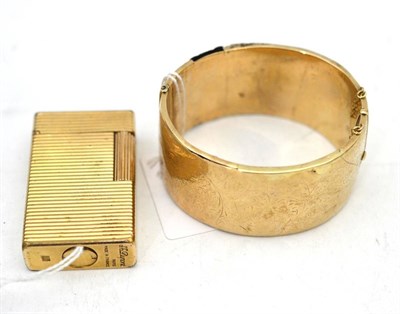 Lot 575 - A Dupont gold plated lighter and a 9ct gold hollow bangle (a.f.)