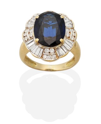 Lot 440 - A Sapphire and Diamond Cluster Ring, an oval cut sapphire in a claw setting, within an...