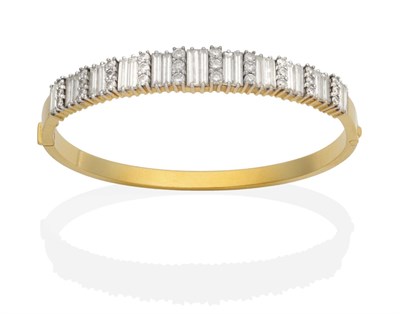 Lot 447 - A Diamond Bangle, graduated pairs of baguette cut diamonds spaced by sets of three round...