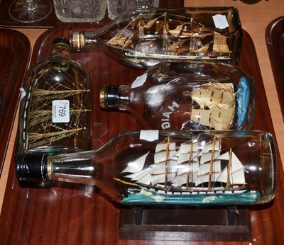 Lot 769 - Ships In Bottles: three three-masted sailing vessels and one two-masted vertically mounted (4)