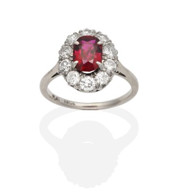 Lot 478 - A Ruby and Diamond Cluster Ring, an oval cut ruby within a border of old cut diamonds, to knife...