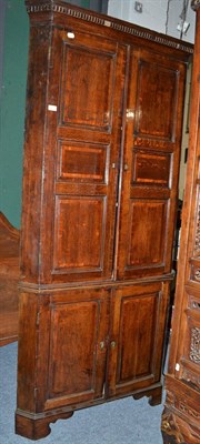 Lot 1101 - A George III oak and mahogany crossbanded free-standing corner cupboard, late 18th century, the...