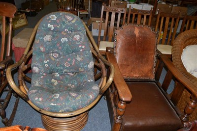 Lot 1212 - An oak reclining armchair with leather seat and back and a modern conservatory chair