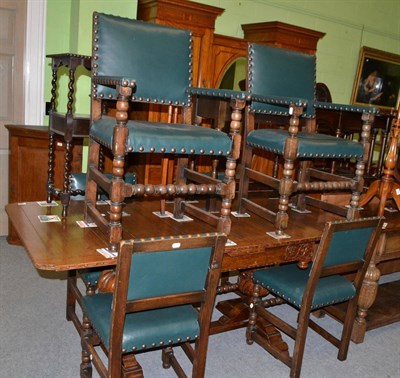 Lot 1351 - An oak draw leaf table on cup and cover legs and a set of six leather upholstered oak dining chairs