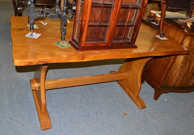 Lot 1355 - A modern oak table on stretcher base with a shaped top