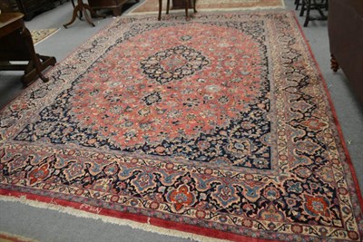 Lot 1408 - A large Mashad carpet North East Iran, the raspberry field of scrolling vines around cusped...