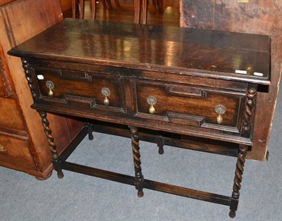 Lot 1439 - A small stained oak dresser base on barley twist supports