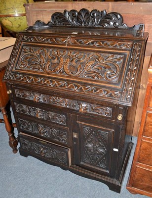 Lot 1441 - A late Victorian carved and stained oak bureau