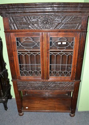 Lot 1450 - A carved oak display cabinet with leaded glass doors bearing a label 'Made of old wood from a...