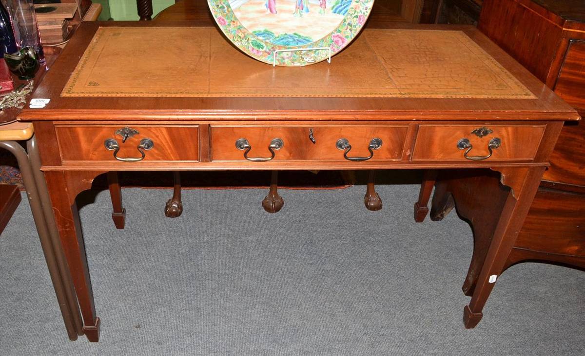 Lot 699 - A reproduction desk with tooled leather top