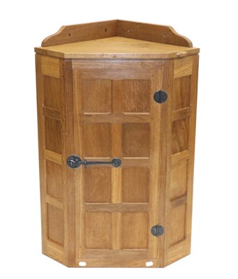 Lot 670 - Mouseman: A Robert Thompson Panelled English Oak Hanging Corner Cupboard, the single door...